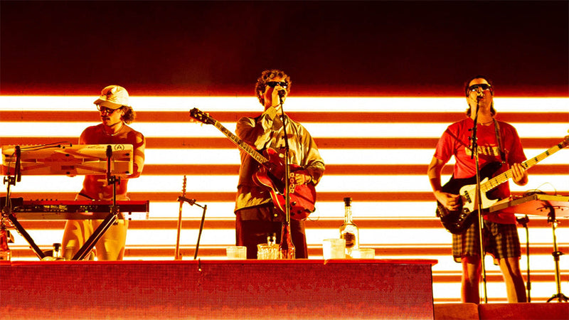 Rawayana tocando en vivo en un escenario iluminado de rojo