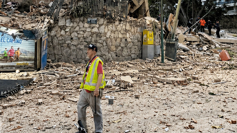 Trabajador con chaleco reflectante entre los escombros de un edificio tras el terremoto en Venezuela