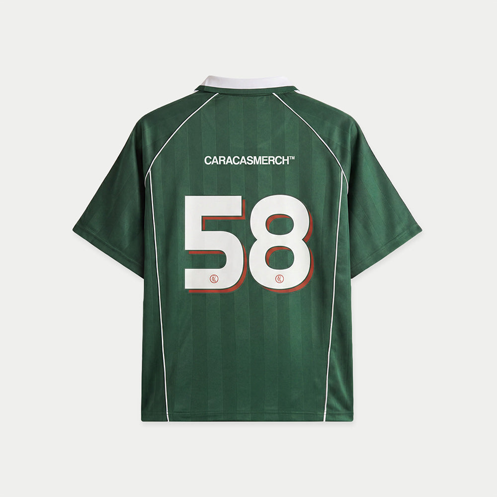 Green soccer-style jersey back view with “CARACASMERCH” text on upper back and large number 58 in white with red outline – Caracas Merch