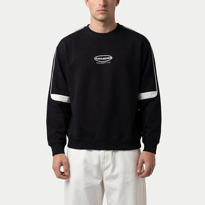 Hombre llevando la sudadera oversized negra «Caracas» de Caracas Merch con franjas blancas y pantalón crema