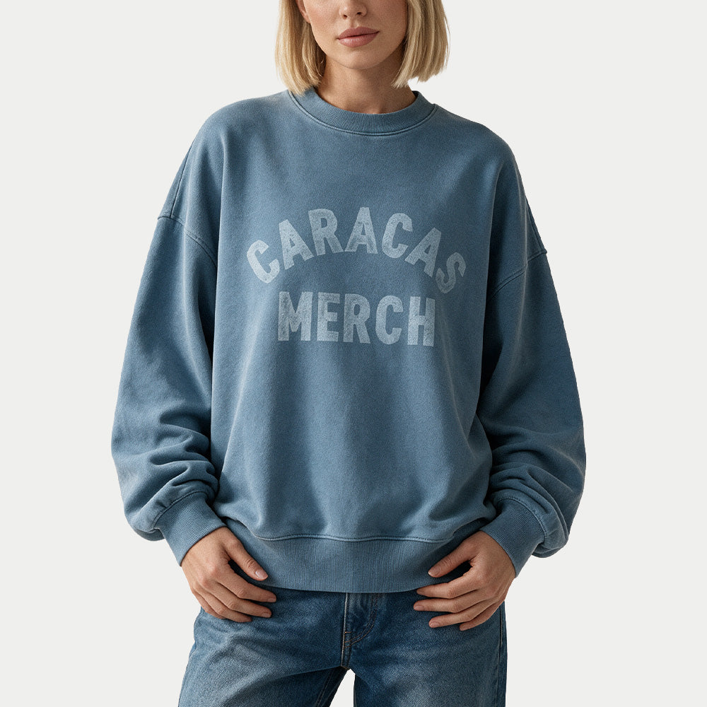 Weibliches Model im blauen Oversized Vintage-Wash-Crewneck von Caracas Merch, Vorderansicht
