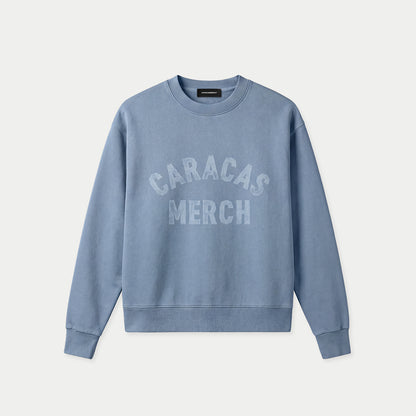 Blauer Oversized Vintage-Wash-Crewneck von Caracas Merch mit gebogenem „Caracas Merch“-Logo auf der Brust, Vorderansicht