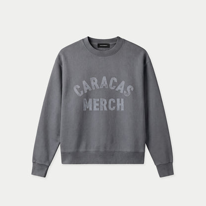 Grauer Oversized Vintage-Wash-Crewneck von Caracas Merch mit gebogenem „Caracas Merch“-Logo auf der Brust, Vorderansicht