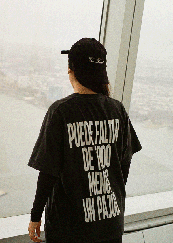 Animation of a person seen from behind wearing the black Puede faltar de todo menos un pajuo t-shirt by Caracas Merch