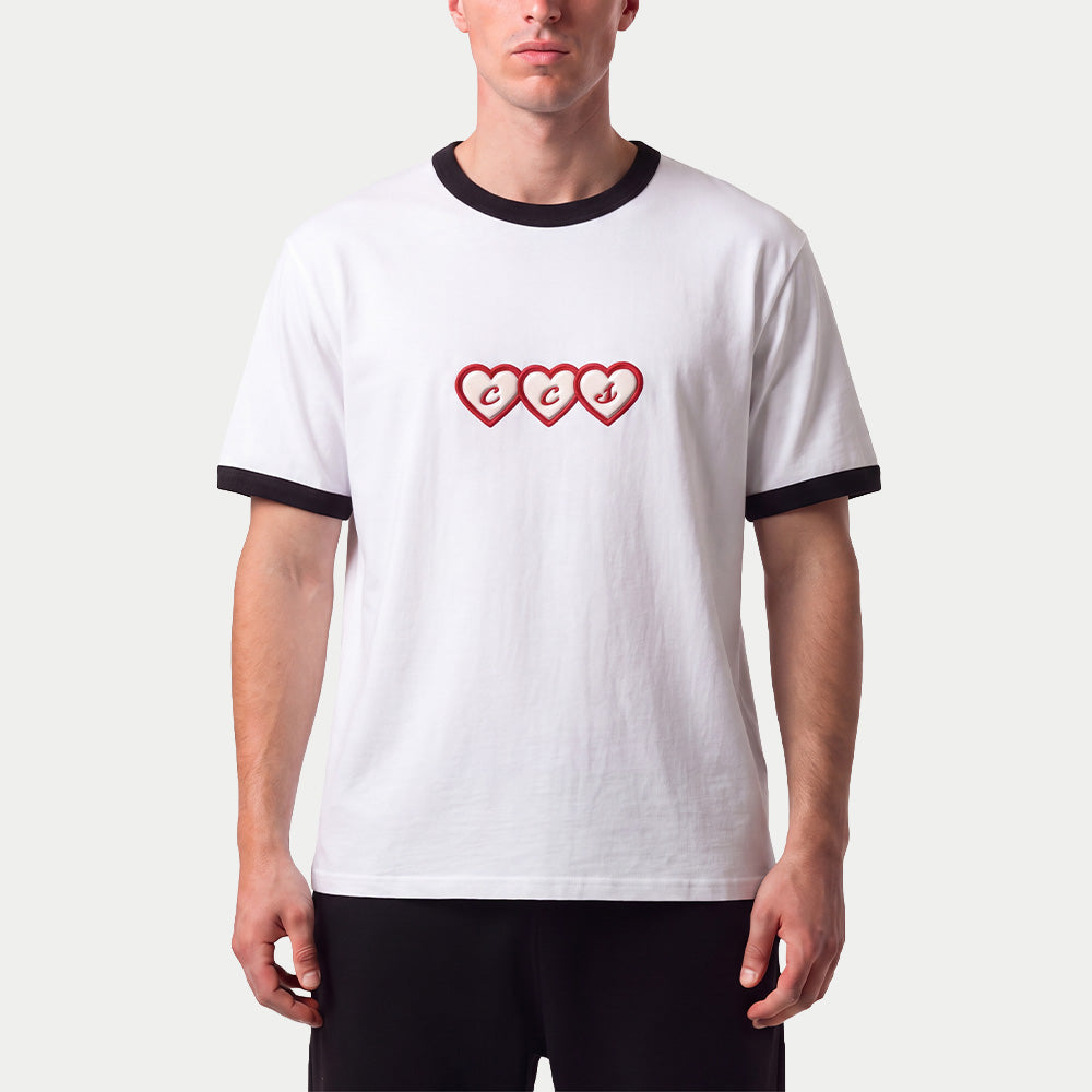 Model trägt das Slim-Fit-T-Shirt „CCS Hearts“ von Caracas Merch in Weiß