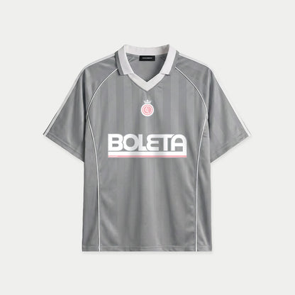 Grey soccer-style jersey front view with striped texture, V-neck collar, and bold “BOLETA” graphic across the chest – Caracas Merch