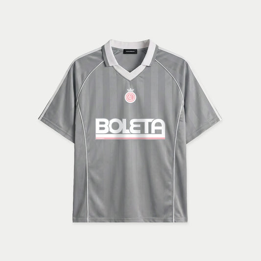 Grey soccer-style jersey front view with striped texture, V-neck collar, and bold “BOLETA” graphic across the chest – Caracas Merch