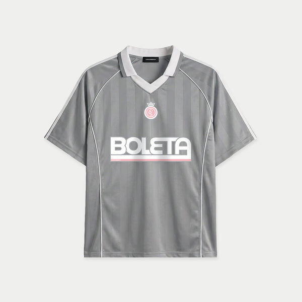 Grey soccer-style jersey front view with striped texture, V-neck collar, and bold “BOLETA” graphic across the chest – Caracas Merch