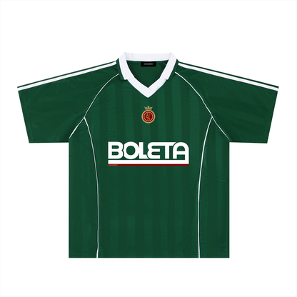 Green soccer-style jersey front view with striped texture, V-neck collar, and bold “BOLETA” graphic across the chest – Caracas Merch