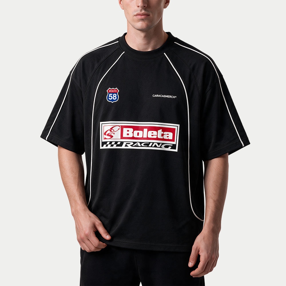 Male model wearing the black Boleta Racing jersey by Caracas Merch, front view