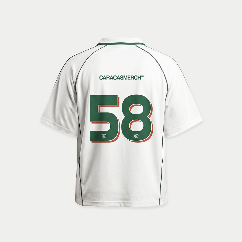 White soccer-style jersey back view with “CARACASMERCH” text on upper back and large number 58 in green with red outline – Caracas Merch