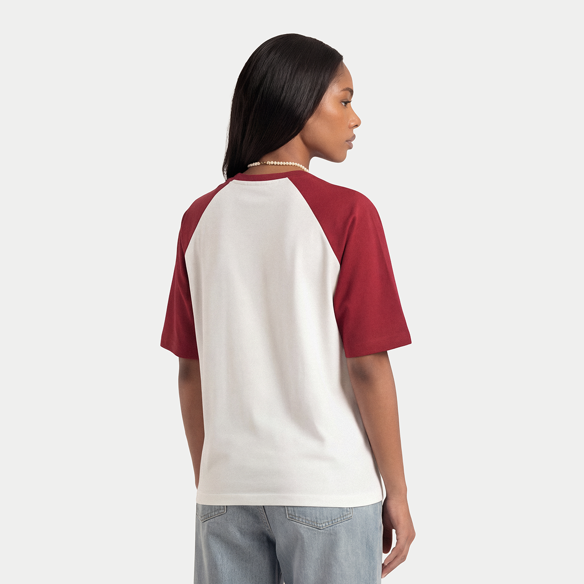 Back view of model wearing white and burgundy Caracas Merch raglan t-shirt