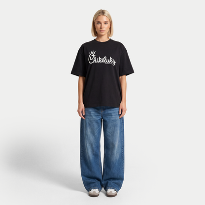 Female model wearing black Chikiluky graphic t-shirt in full body outfit
