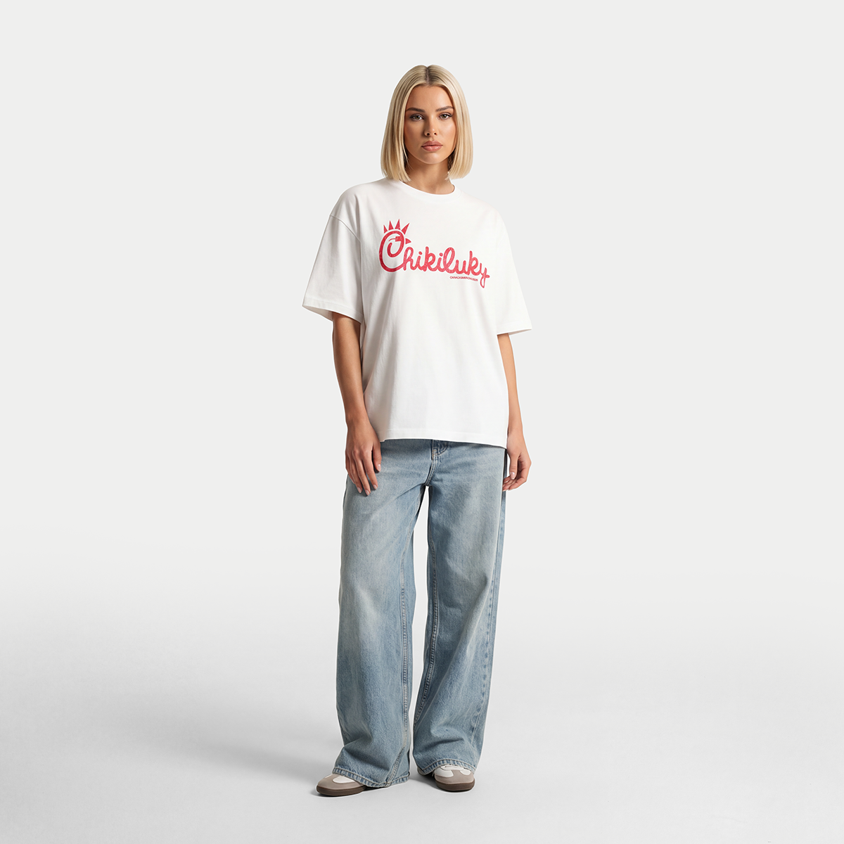 Female model wearing white Chikiluky graphic t-shirt in full body outfit