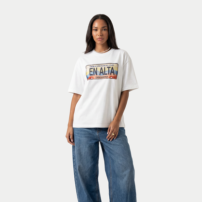 Female model wearing white En Alta license plate graphic t-shirt by Caracas Merch