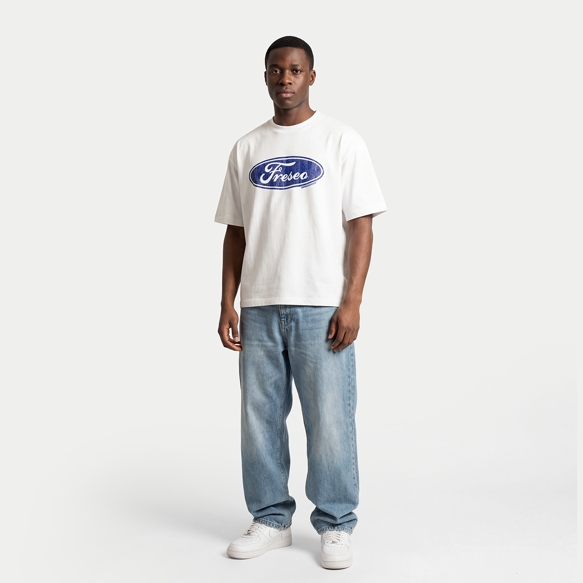 Full body male model wearing white Freseo logo t-shirt by Caracas Merch