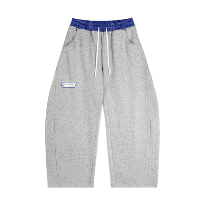 Front view of gray tracksuit sweatpants with blue waistband and Caracas Merch logo