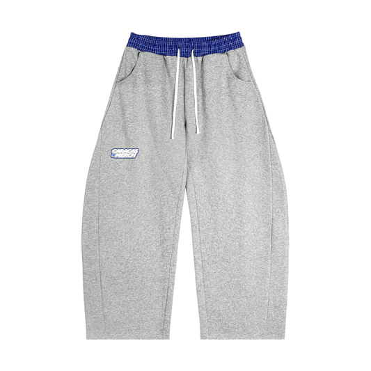 Front view of gray tracksuit sweatpants with blue waistband and Caracas Merch logo