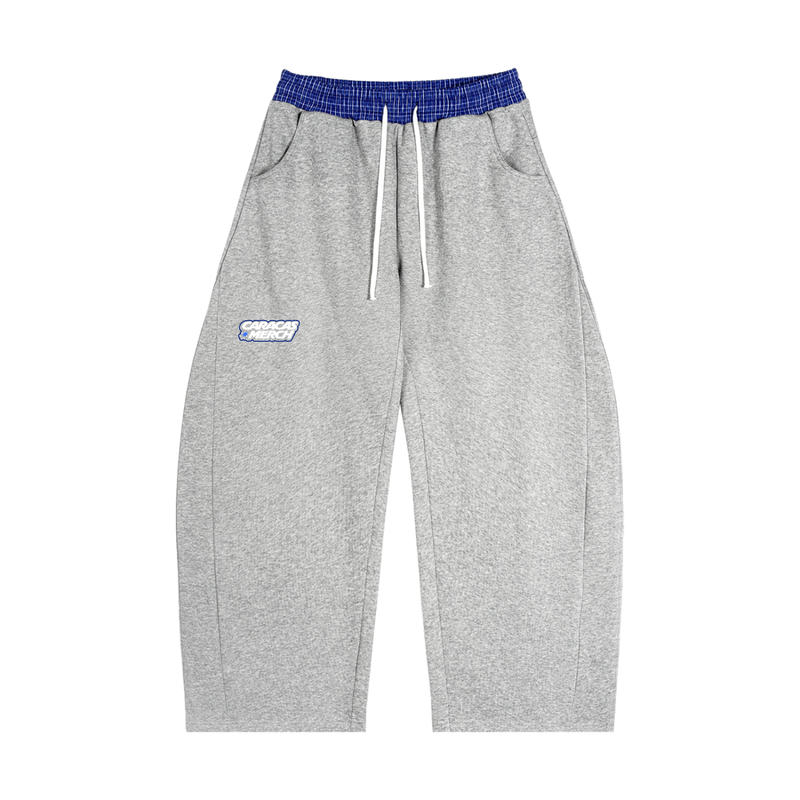 Front view of gray tracksuit sweatpants with blue waistband and Caracas Merch logo