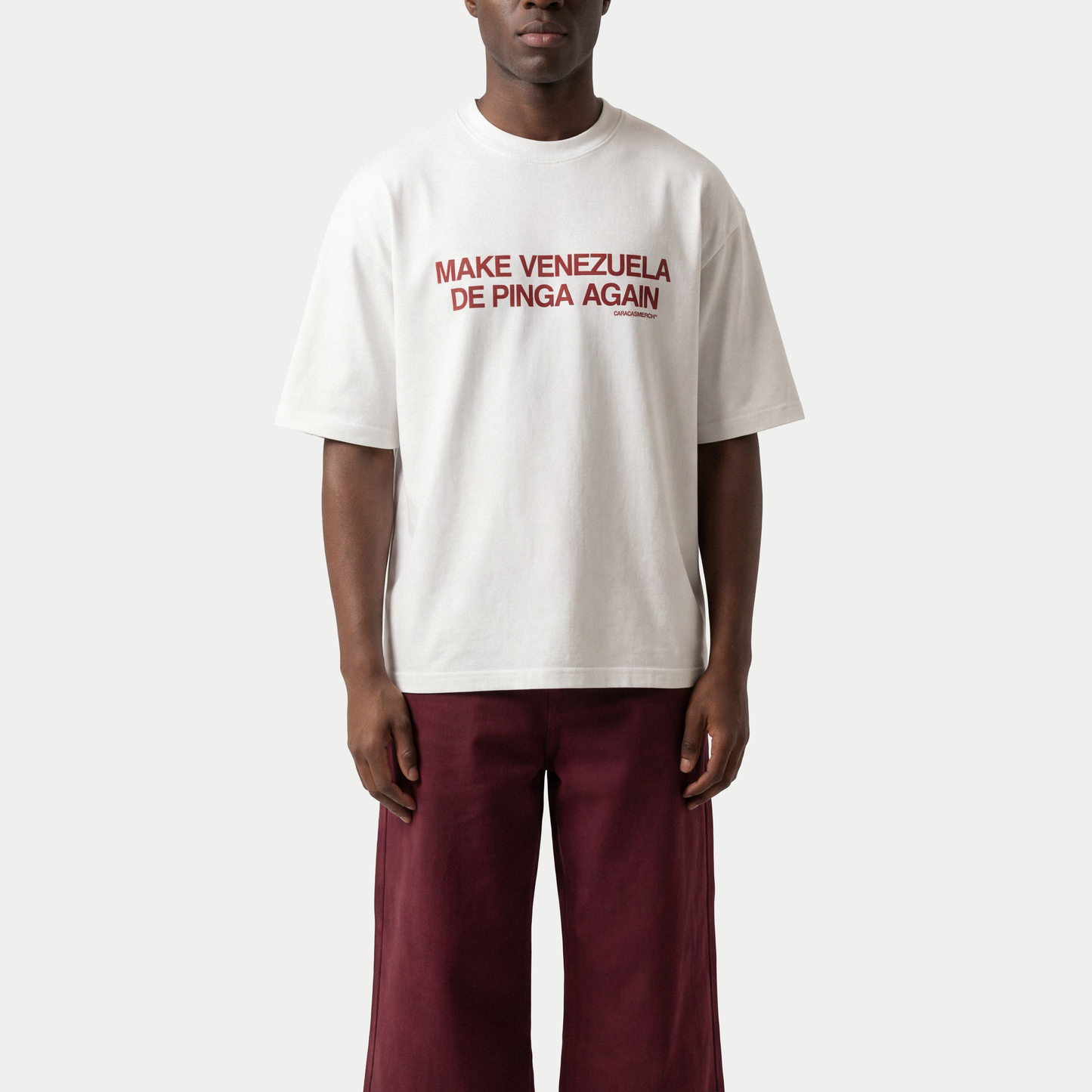 Male model wearing white “Make Venezuela De Pinga Again” t-shirt by Caracas Merch