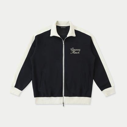 Navy zip up jacket with cream trim and Caracas Merch embroidery front view