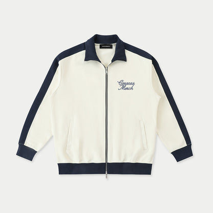 Front view of cream Caracas Merch zip jacket with navy details