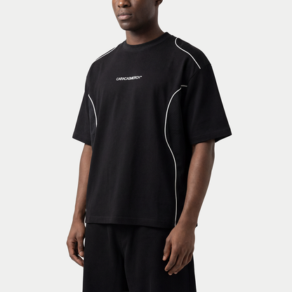 Black performance streetwear t-shirt worn by model with contrast white piping