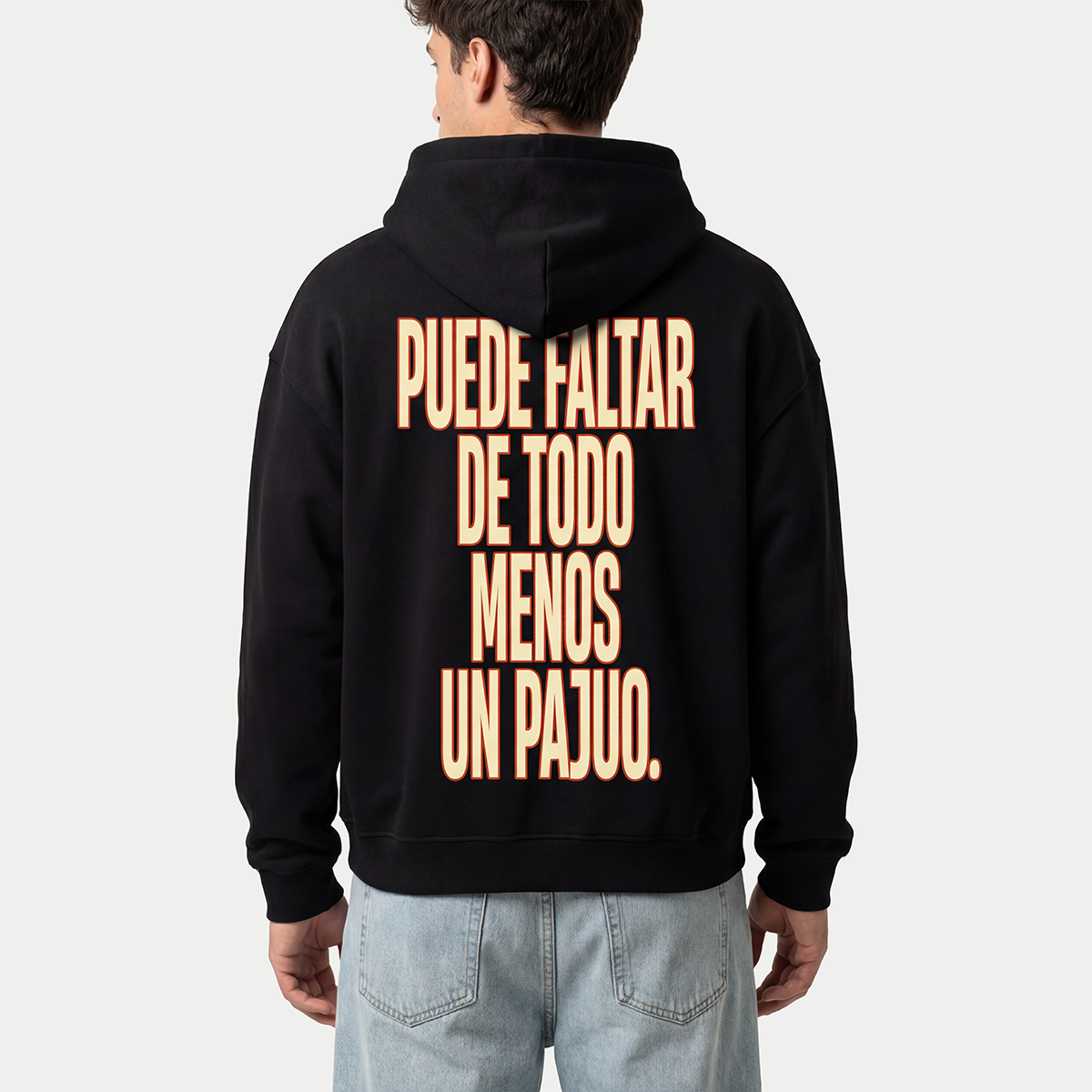 Model wearing black hoodie with “Puede faltar de todo menos un Pajuo” print on back