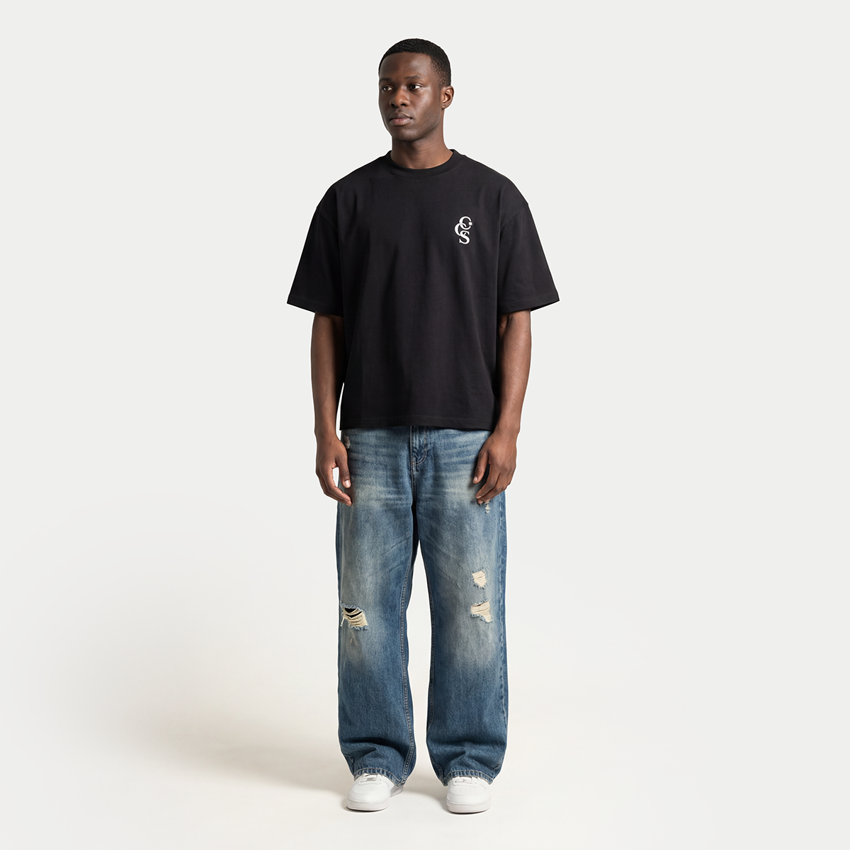 Full body model wearing black CCS t-shirt by Caracas Merch