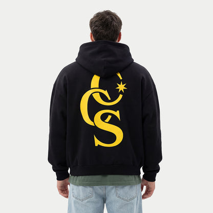 model wearing CCS Monogram Hoodie black with yellow back print Caracas Merch streetwear hoodie