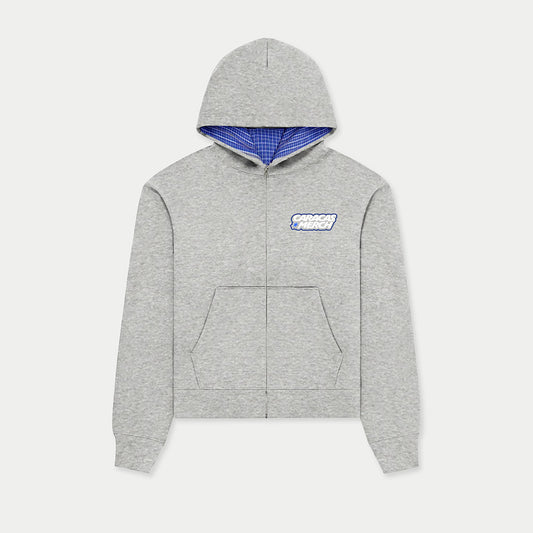 Front view of gray zip-up hoodie by Caracas Merch with blue inner hood lining and DTF logo