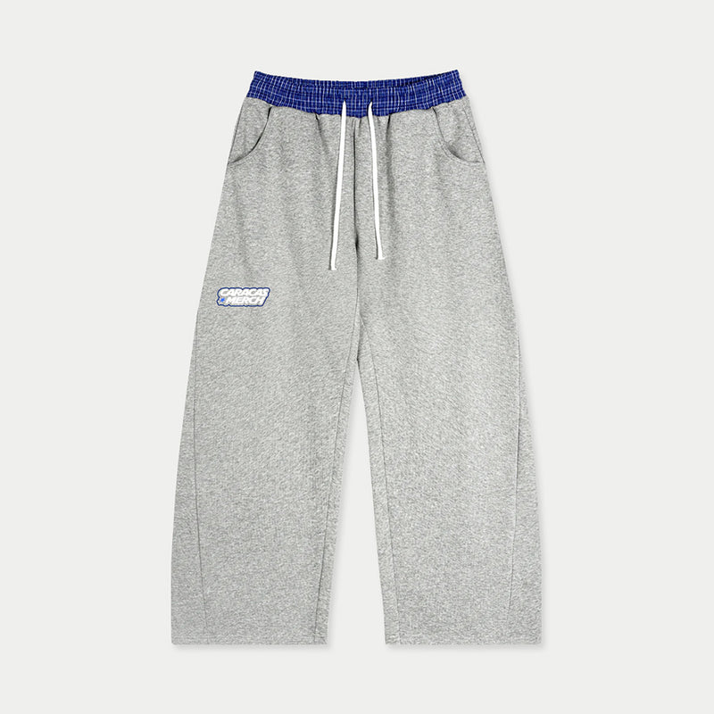 Front view of gray tracksuit sweatpants with blue waistband and Caracas Merch logo