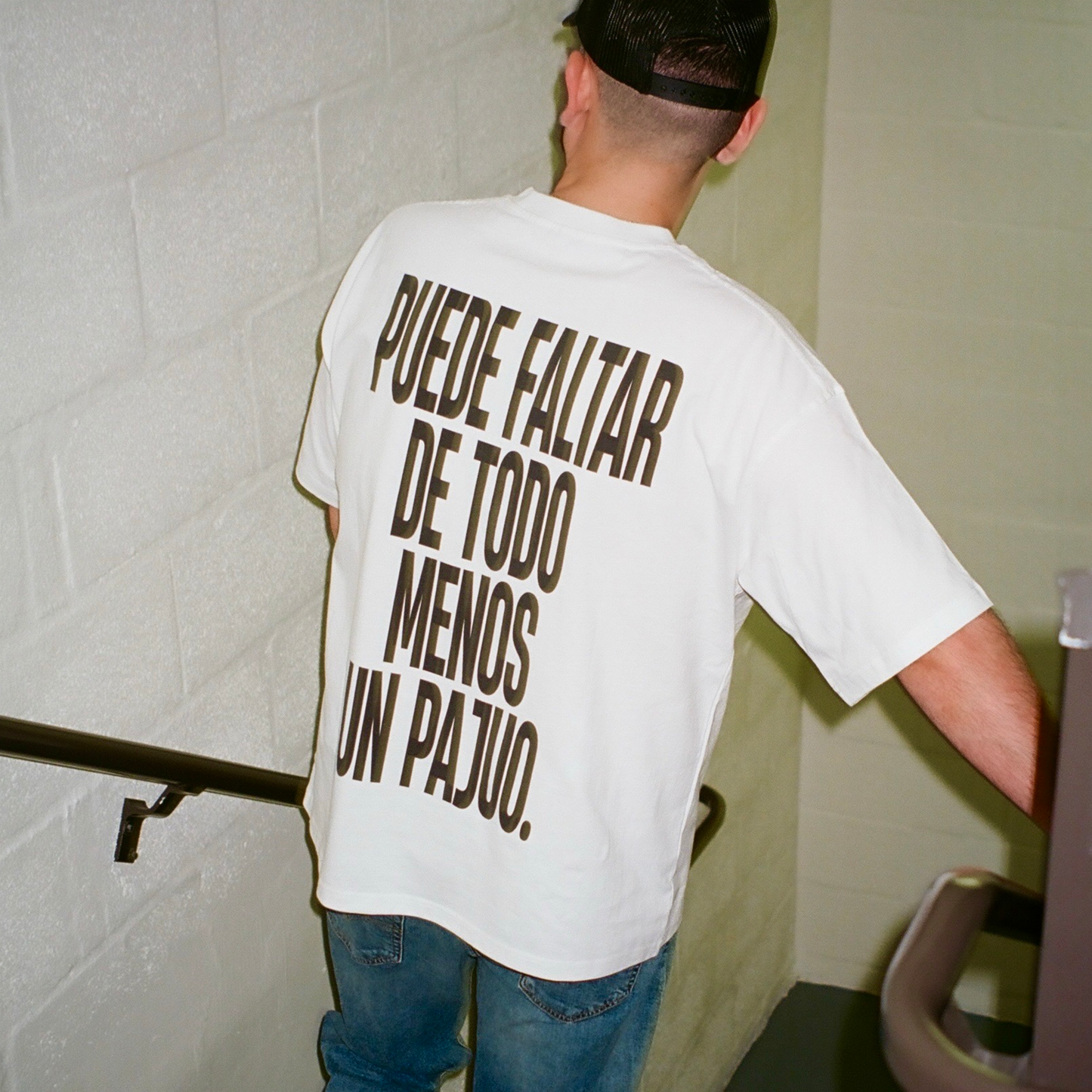 Male model wearing puede faltar de todo menos un pajuo white tee