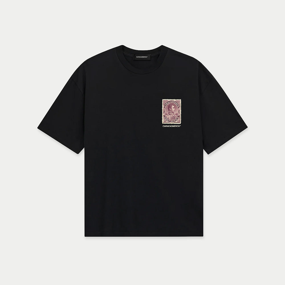 Black oversized t-shirt front view with large vintage blue postage stamp graphic featuring a classic portrait and “la calle que te falta” text – Caracas Merch