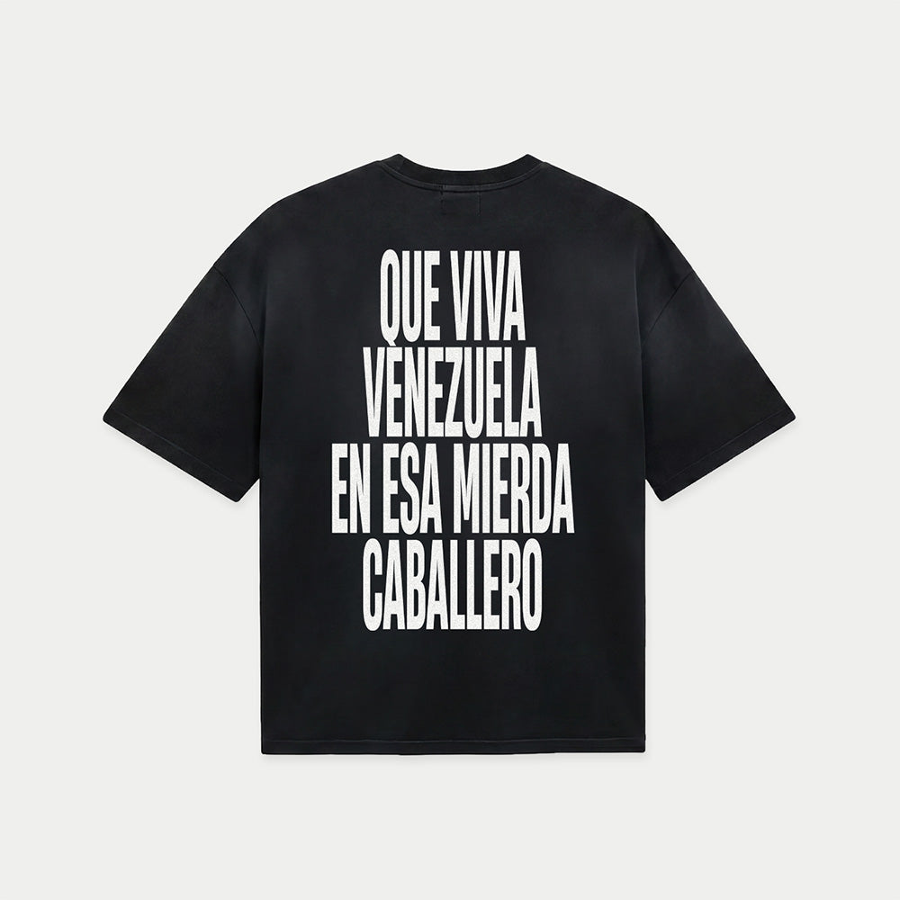 Black oversized t-shirt back view with bold black text graphic reading “Que viva Venezuela en esa mierda caballero” – Caracas Merch