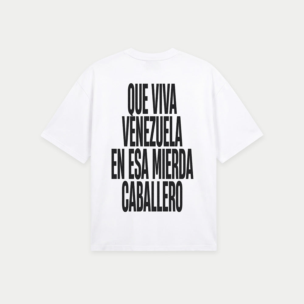 White oversized t-shirt back view with bold black text graphic reading “Que viva Venezuela en esa mierda caballero” – Caracas Merch
