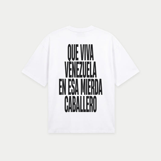 White oversized t-shirt back view with bold black text graphic reading “Que viva Venezuela en esa mierda caballero” – Caracas Merch