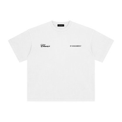 White oversized t-shirt front view with bold black text graphic reading “Que viva Venezuela en esa mierda caballero” – Caracas Merch