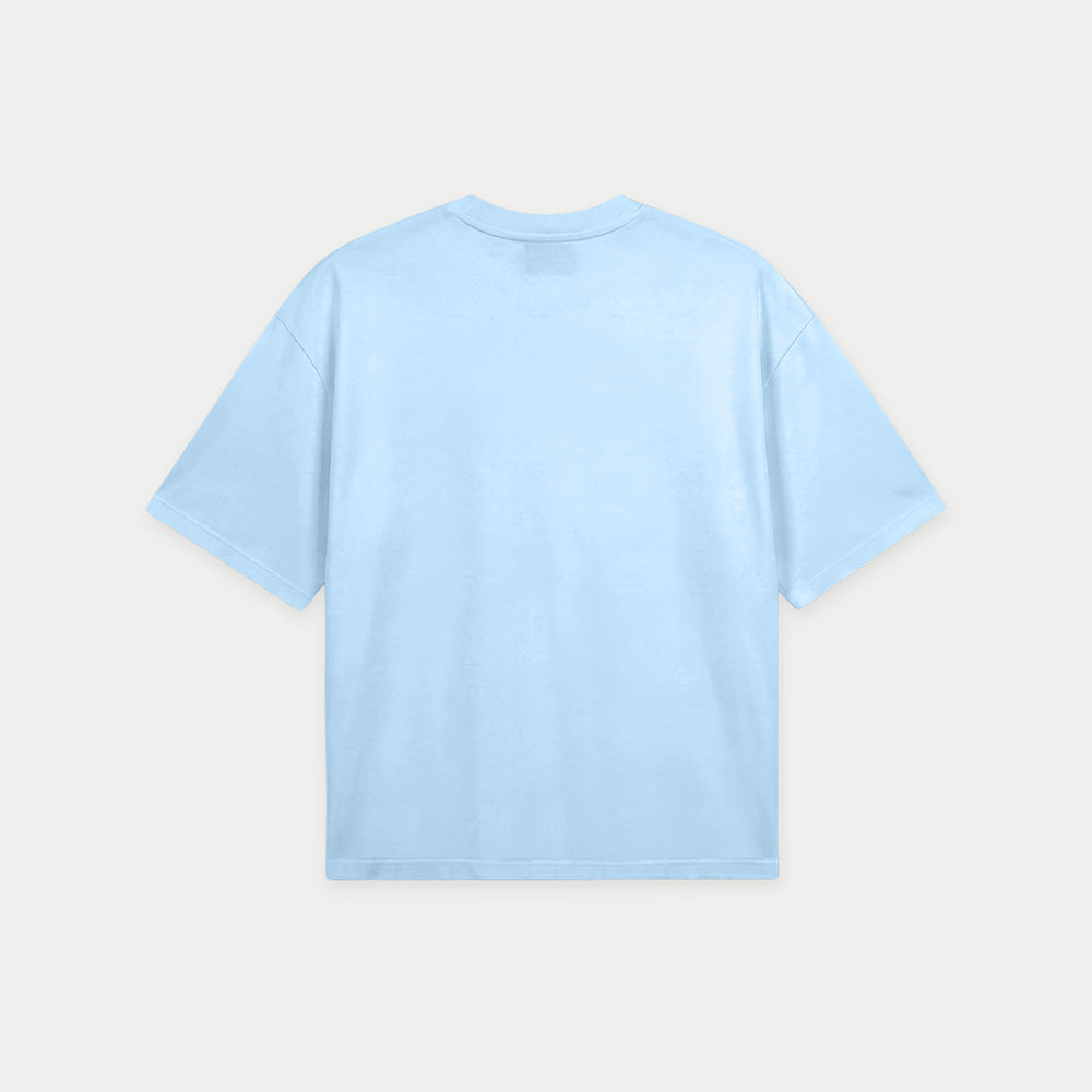 Light blue oversized t-shirt back view with bold “Super Fresa” graphic in pink and black with stars and Caracas Merch branding
