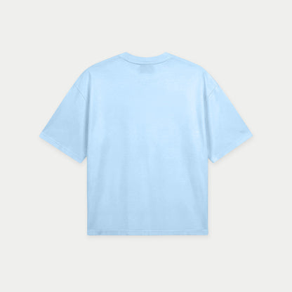 Light blue oversized t-shirt back view with bold “Super Fresa” graphic in pink and black with stars and Caracas Merch branding