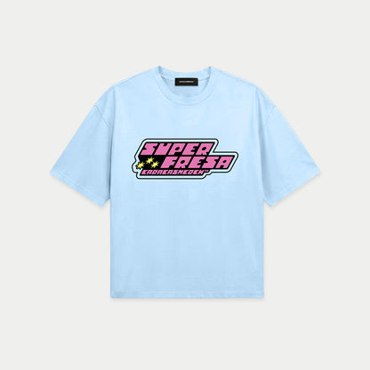 Light blue oversized t-shirt front view with bold “Super Fresa” graphic in pink and black with stars and Caracas Merch branding