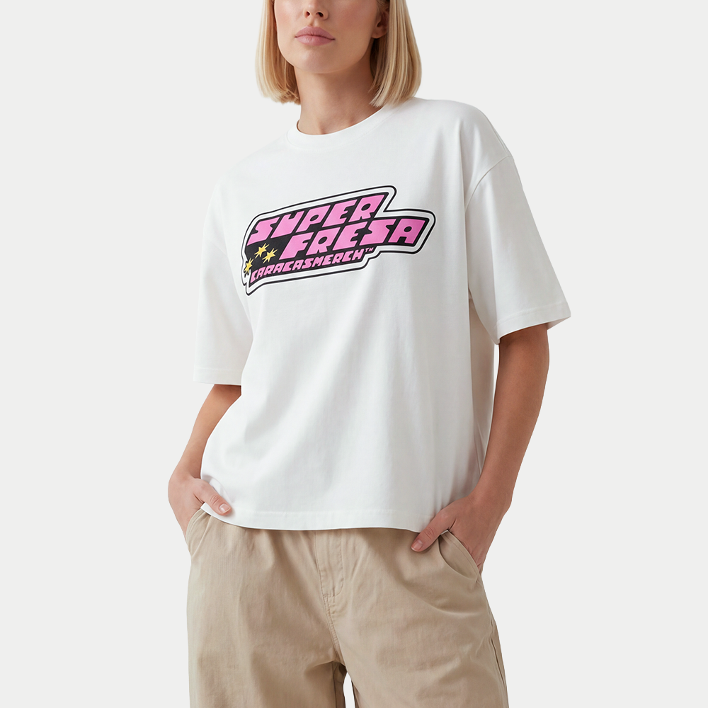 Female model wearing boxy t-shirt front view with bold “Super Fresa” graphic in pink and black with stars and Caracas Merch branding