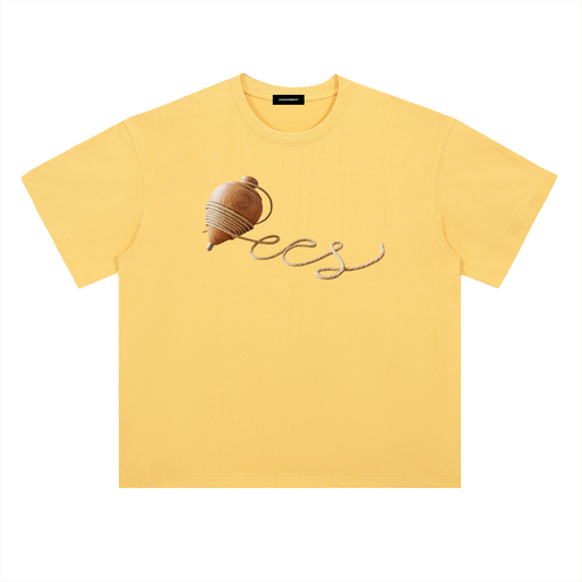 Yellow oversized t-shirt front view with wooden spinning top graphic forming “ccs” in rope-style lettering – Caracas Merch