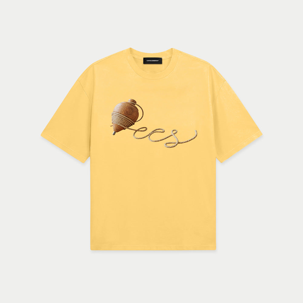 Yellow oversized t-shirt front view with wooden spinning top graphic forming “ccs” in rope-style lettering – Caracas Merch