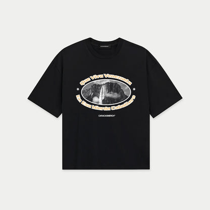 Black boxy t-shirt front view with oval graphic featuring Angel Falls image and “Que viva Venezuela en esa mierda caballero” text – Caracas Merch