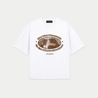 White boxy t-shirt front view with oval graphic featuring Angel Falls image and “Que viva Venezuela en esa mierda caballero” text – Caracas Merch
